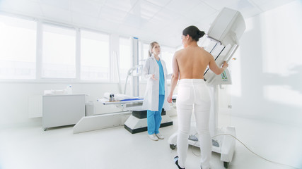 In the Hospital, Mammography Technologist / Doctor adjusts Mammogram Machine for a Female Patient....