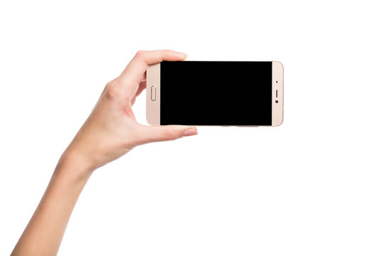 The hand holds the smartphone. Blank screen. Isolated on white.