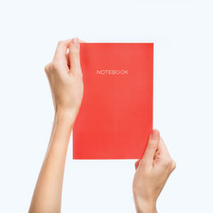 Hand holds a book on white isolated background. Space