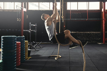 Sportsman doing rope climbing exercise