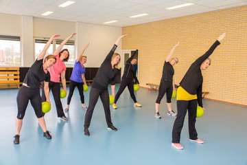 Fototapeta na wymiar Group of women with balls doing stretching exercises