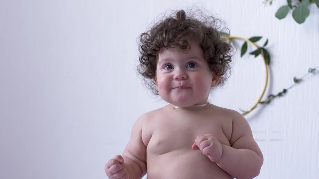 funny naked chubby kid having fun in the studio on photo session close-up