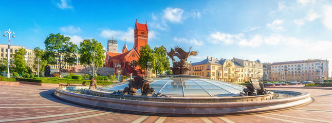 Panoramic view on Red Church or Church Of Saints Simon and Helen, Fountain at independence Square in Minsk, Belarus. - obrazy, fototapety, plakaty