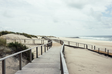 Fototapeta na wymiar Wooden footbridge of Costa Nova beach, Aveiro, Portugal.