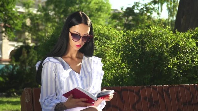 Gorgeous brunette finished of reading book in the park