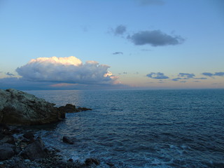 An amazing caption of a beautiful blue sea, small waves and  a hidden sunset over the horizzon in sumer days