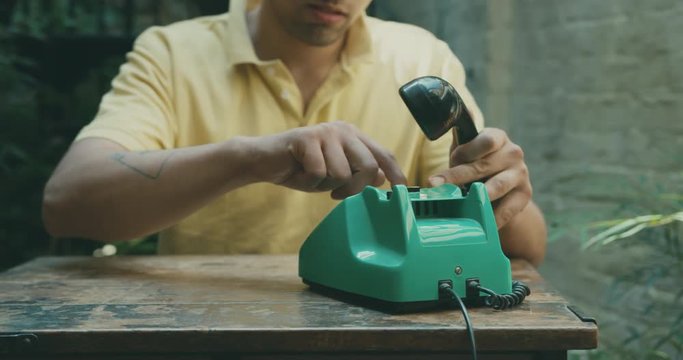 Man making phone call using rotary telephone