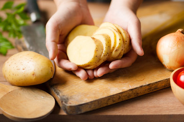 Chef prepare potatoes on chopping board for cook a potato salad at kitchen. Salad, vegetarian food,...
