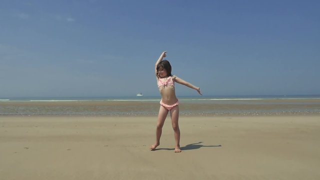 belle enfant faisant la roue sur la plage
(slow motion)