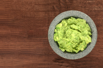 A photo of guacamole sauce in a molcajete, traditional Mexican mortar