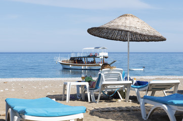 Beautiful concept of the summer vacation at sea, a girl with a glass of a cooling drink rests on a lounger