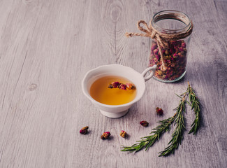 A cup of roses tea and dried rose buds.