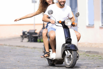 Cool man and beautiful girl riding on  scooter with  expression