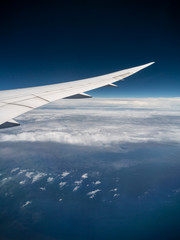Fototapeta premium View from airplane window with blue sky and white clouds, background for travel holiday trip, Aircraft on the sky.