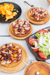 Vegetable salad, potatoes and galician style cooked octopus with paprika and olive oil. Pulpo a la gallega