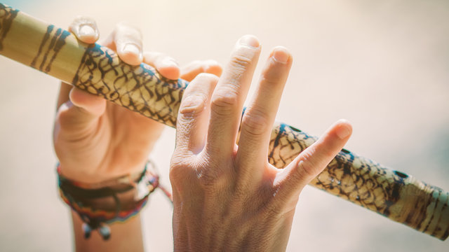 Young woman playing bamboo flute on the beach