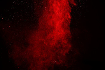 Launched colored powder, isolated on black background. Red dust splatted with black background.