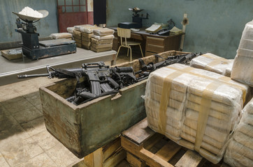 Drug warehouse This scene was staged to recreate an illegal warehouse, weapons are movie  props fake guns. - obrazy, fototapety, plakaty