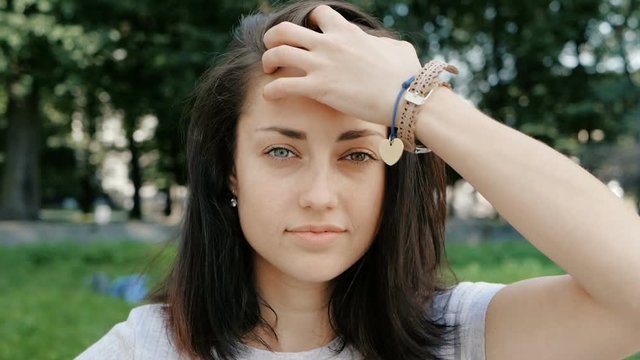 Portrait of happy beautiful caucasian woman with different eyes correct the hairstyle heterochromia, Slow Motion