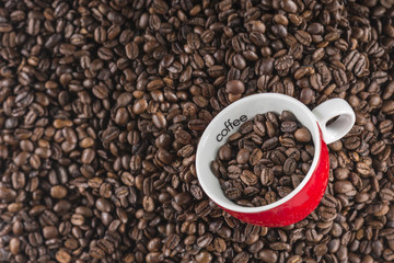 Coffee grains in red cup with selective focus Great coffee grain background with special red cup