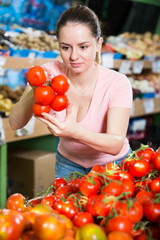 Fototapeta na wymiar Young woman choosing tomatoes