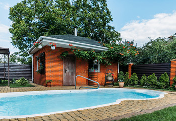 wooden country house with swimming pool near by, trees and cloudy sky