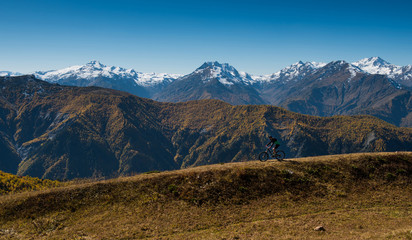 Mountain biker riding on bike in autumn mountains