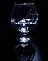 a glass of water on a black background with reflection