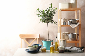 Fototapeta na wymiar Fresh olive oil and kitchen utensils on table