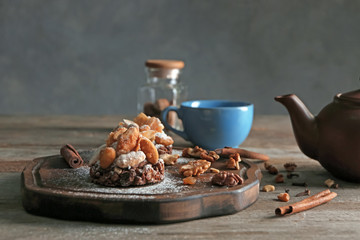 Board with tasty praline cakes on table
