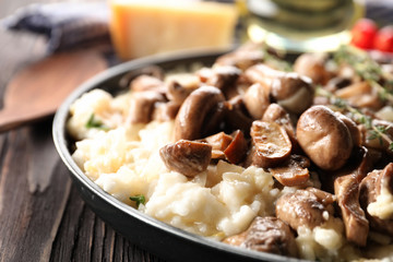 Tasty risotto with mushrooms on frying pan, closeup