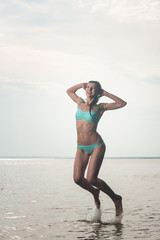 Young beautiful woman jumping in the sea, lots of splashing