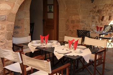 Tables served for breakfast in one of the hotels inside of the medieval castle town of Monemvasia, Peloponnese, Greece, June 2018.