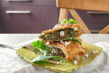 Tasty pie with spinach on plate