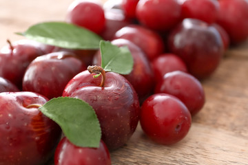 Ripe juicy plums on wooden table