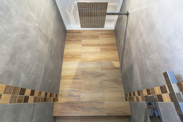 New bathroom interior in the house. Gray concrete tiles with wooden decor.