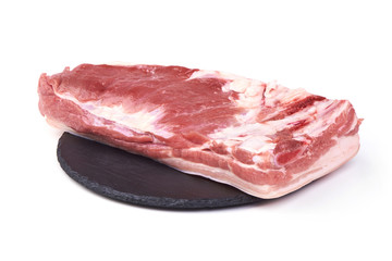 Raw pork meat, served on the slate plate, isolated on white background.
