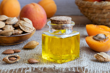 A bottle of apricot kernel oil with fresh apricots