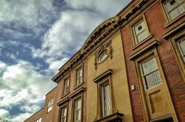 Fototapeta premium Traditional early twentieth century British municipal brick building (originally RRDC - Rotherham Rural District Council) with ornate architectural sculpture of grapes around rose window