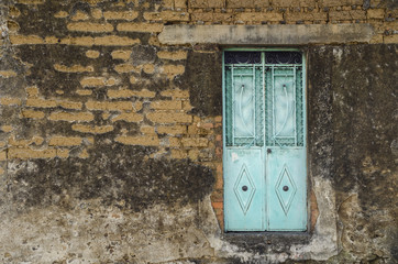 Cyan Door. Floating door in a run-down wall in Mexico