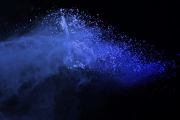 Abstract powder splatted on black background.Freeze motion of colored powder exploding islate with...
