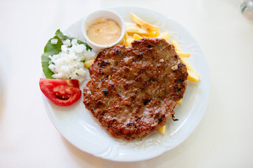 Delicious food, pljeskavica - tasty grilled dish of spiced meat patty mixture of pork, beef and lamb, is a national dish of Montenegro, Serbia, also popular in Bosnia and Herzegovina and Croatia