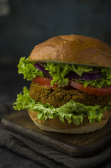 Vegan burger with vegetables on cutting board