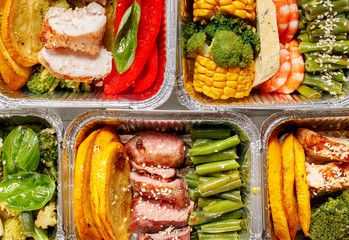 Healthy meal prep containers with vegetables, chicken, beef and shrimp grilled. Close-up, view top.