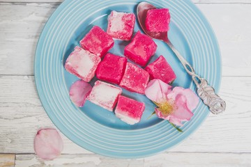 rose lokum and rose petals on a blue plate