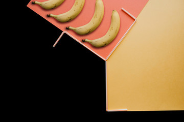 A creative photograph with a bananas and small tubes on a bright background