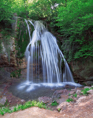 Naklejka na ściany i meble Big waterfall at the green forest in europe