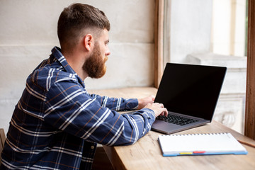 Young man chatting via net-book during work break in coffee shop