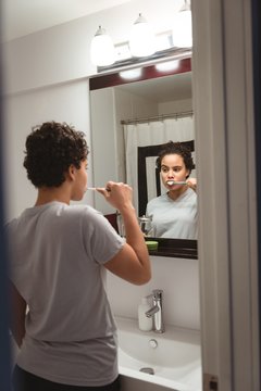 Woman brushing off her teeth in washroom