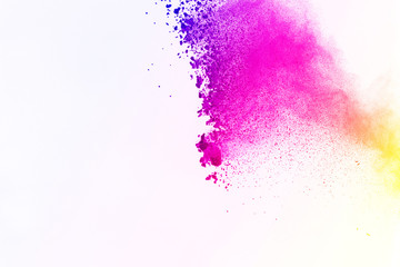 Freeze motion of color powder exploding on white background. Colored powder splatted.